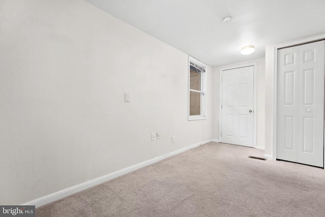 unfurnished bedroom with light colored carpet and a closet