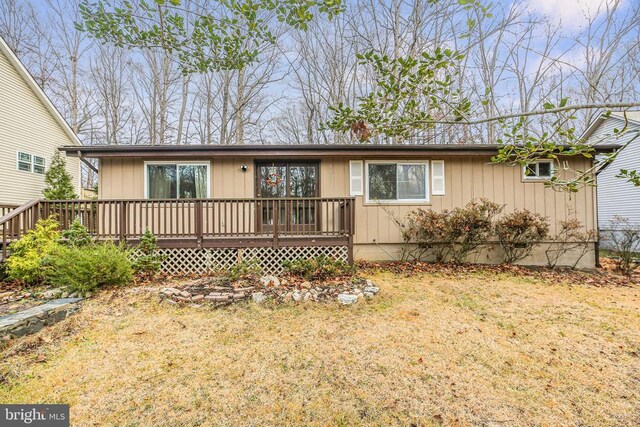 single story home with a front yard and a deck