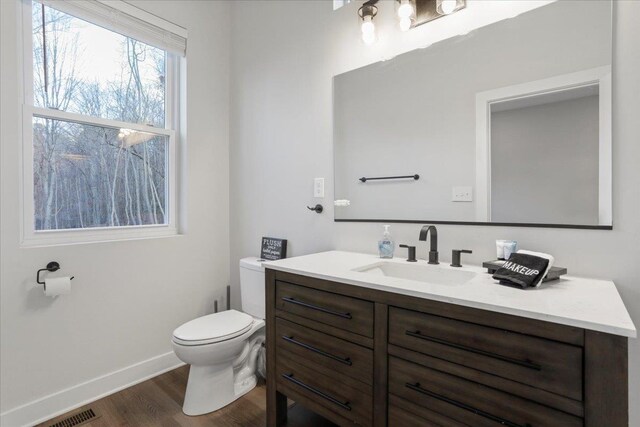 bathroom featuring vanity, hardwood / wood-style floors, and toilet