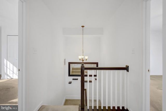 stairway with visible vents, carpet floors, baseboards, and a chandelier