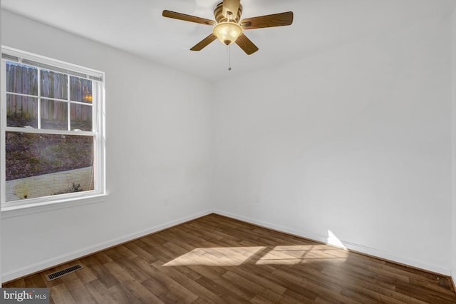 spare room with visible vents, baseboards, wood finished floors, and a ceiling fan