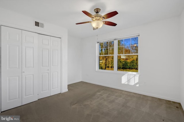 unfurnished bedroom featuring baseboards, visible vents, carpet floors, ceiling fan, and a closet