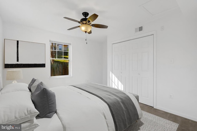 bedroom featuring visible vents, a ceiling fan, a closet, baseboards, and attic access