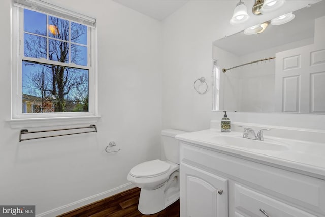 full bath with toilet, wood finished floors, a shower, baseboards, and vanity