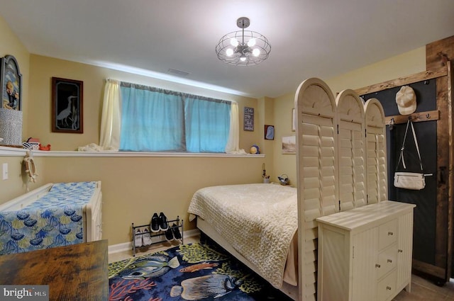 bedroom with baseboards and a chandelier