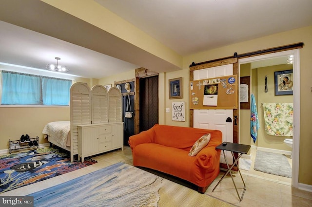 bedroom with a barn door, baseboards, and tile patterned flooring