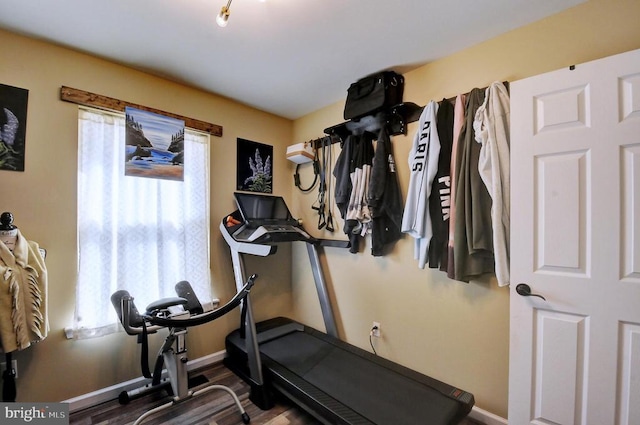 exercise room with baseboards and wood finished floors