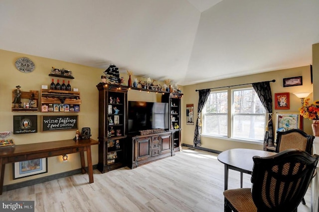 living area featuring baseboards, lofted ceiling, and wood finished floors