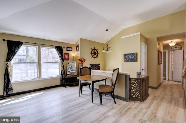 dining space featuring baseboards, lofted ceiling, light wood-style floors, and a notable chandelier