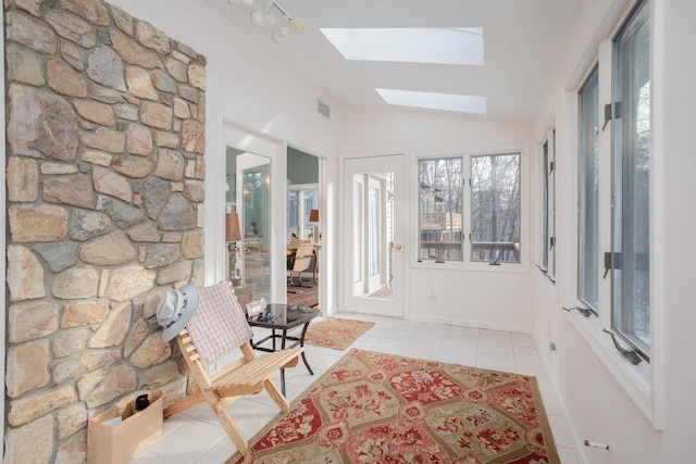 unfurnished sunroom with vaulted ceiling with skylight