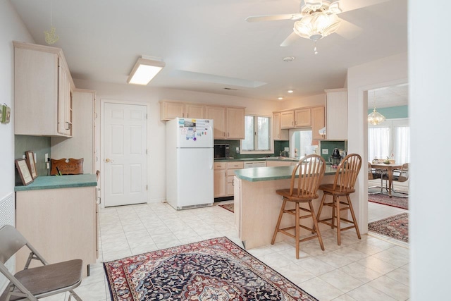 kitchen featuring a kitchen bar, tasteful backsplash, kitchen peninsula, white fridge, and ceiling fan