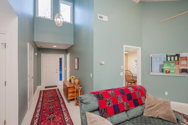 tiled living room featuring a towering ceiling