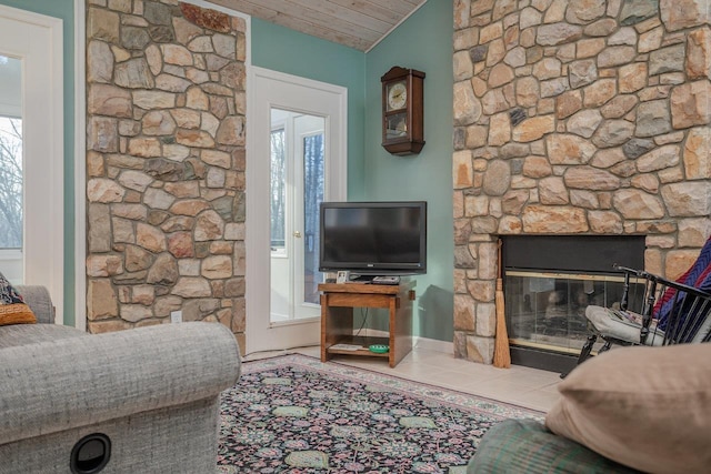 tiled living room featuring lofted ceiling, a stone fireplace, and wooden ceiling