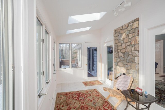 sunroom / solarium featuring lofted ceiling with skylight