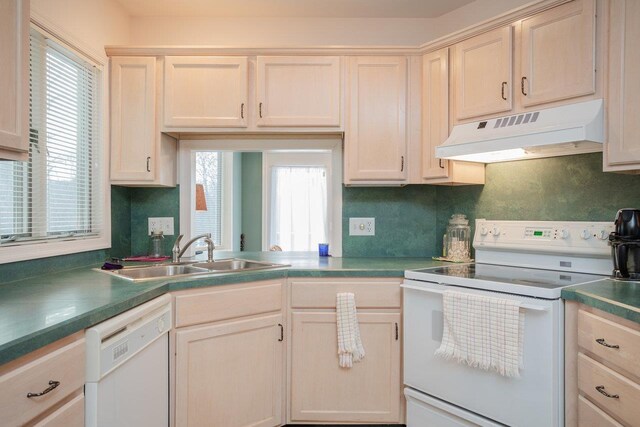 kitchen with sink, white appliances, a wealth of natural light, and backsplash