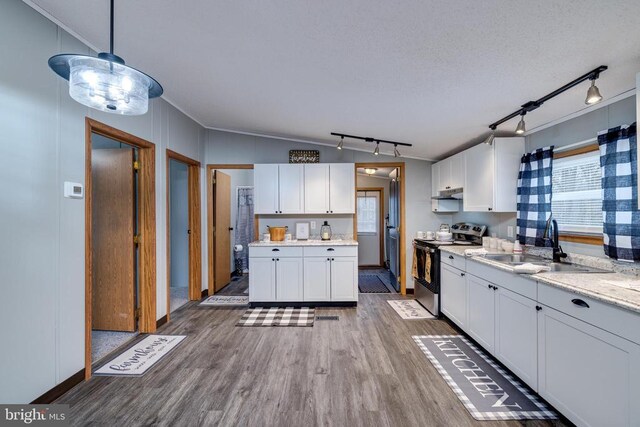 kitchen featuring stainless steel electric range oven, wood-type flooring, sink, white cabinets, and hanging light fixtures