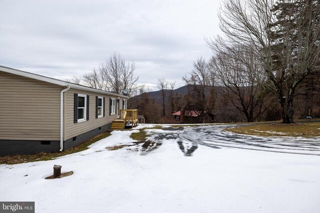 yard covered in snow featuring a mountain view