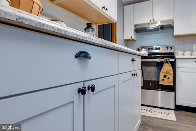 kitchen featuring white cabinetry, wood-type flooring, and stainless steel range with electric cooktop