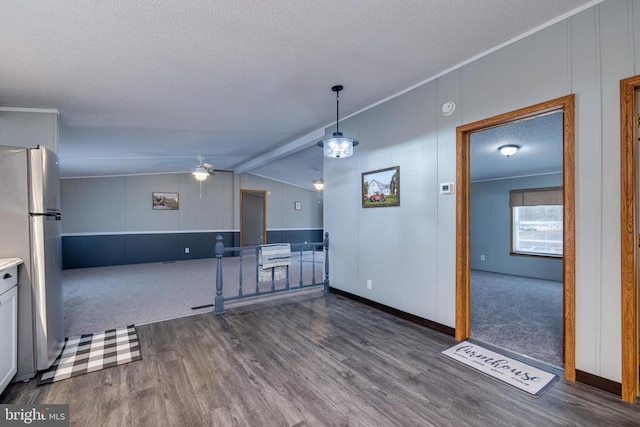 kitchen with stainless steel refrigerator, white cabinetry, dark hardwood / wood-style flooring, and vaulted ceiling