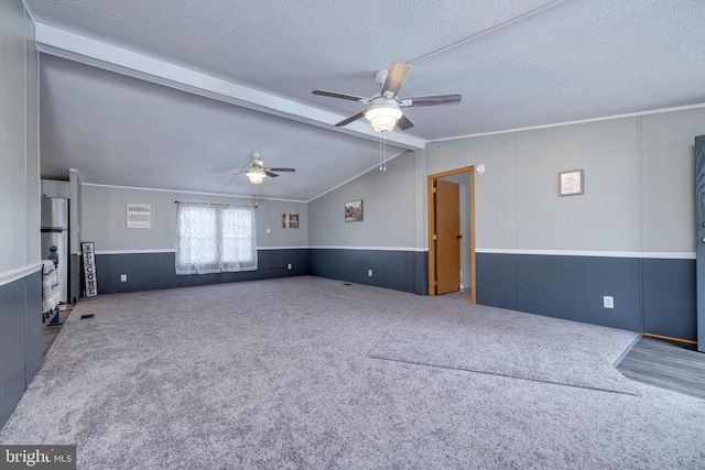 interior space with vaulted ceiling with beams, carpet floors, a textured ceiling, and ceiling fan