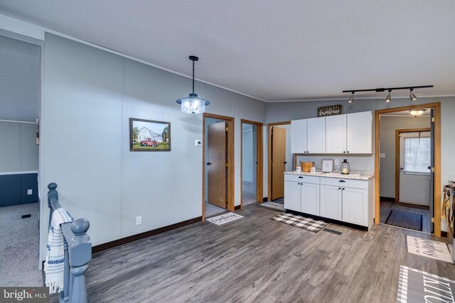 kitchen featuring hardwood / wood-style flooring, hanging light fixtures, and white cabinets