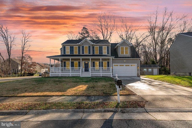 view of front of house featuring a garage, a lawn, and a porch