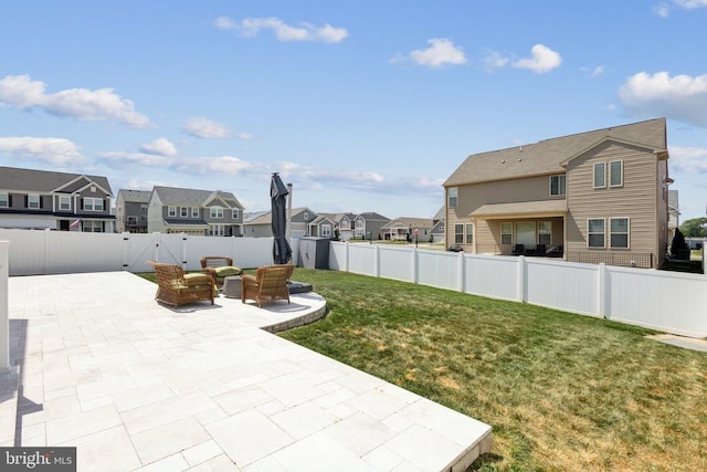 view of yard featuring a patio, a residential view, and a fenced backyard