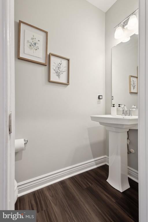 bathroom with baseboards and wood finished floors