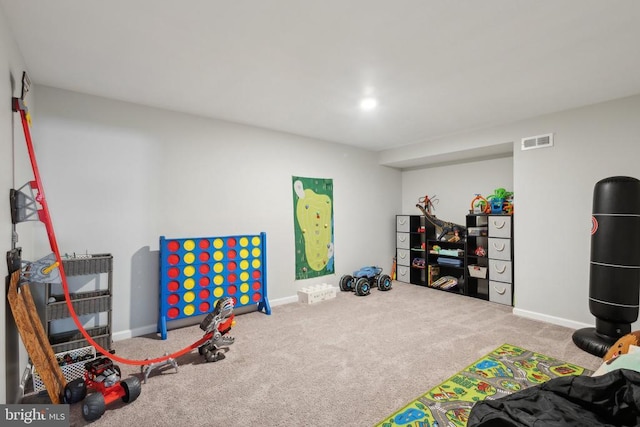 recreation room featuring baseboards, visible vents, and carpet