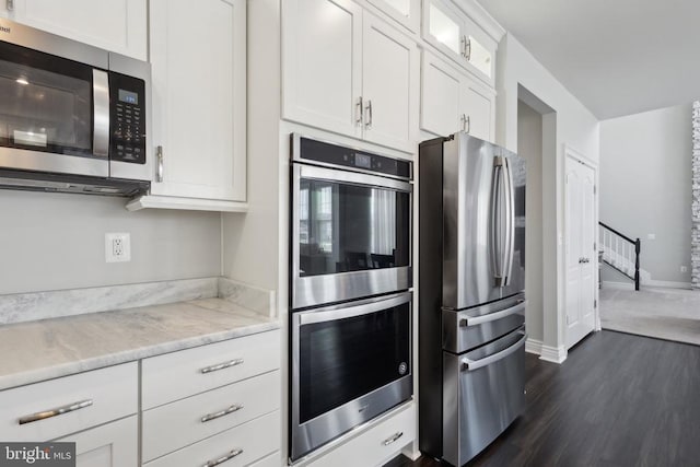kitchen with stainless steel appliances, dark wood finished floors, glass insert cabinets, white cabinets, and baseboards