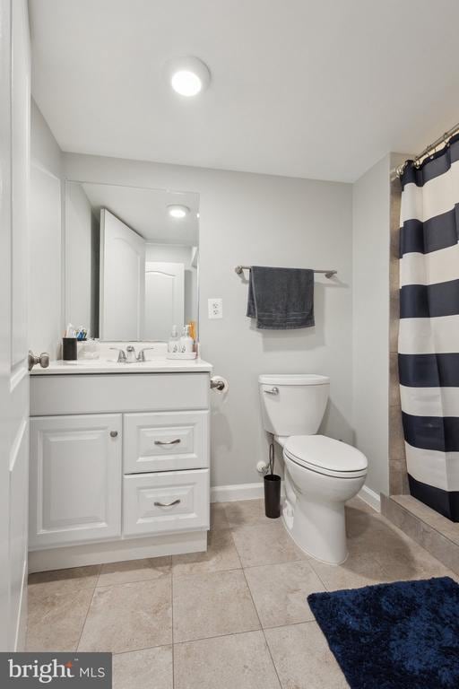 bathroom featuring toilet, baseboards, curtained shower, tile patterned floors, and vanity