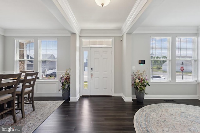 foyer featuring dark wood-style flooring, ornamental molding, and plenty of natural light