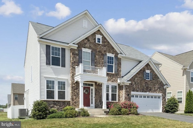 view of front of house with stone siding, cooling unit, aphalt driveway, a front yard, and a balcony