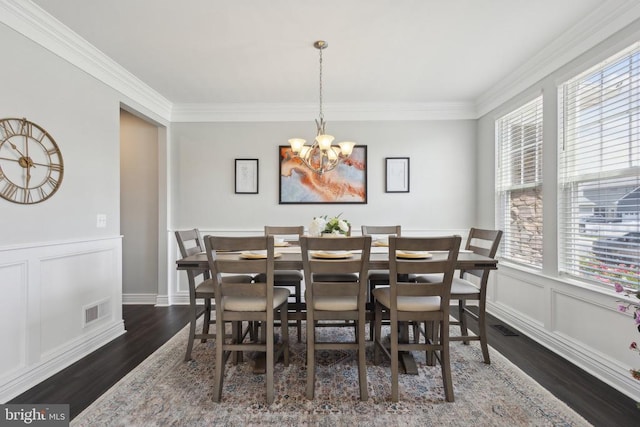 dining room featuring a chandelier, plenty of natural light, visible vents, and wood finished floors