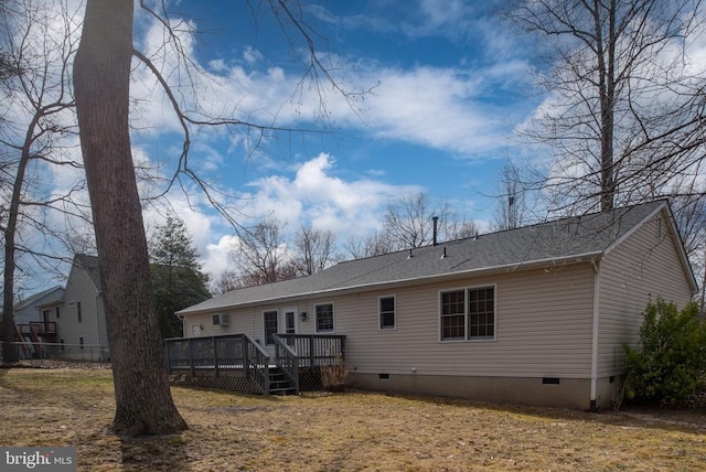 rear view of property with crawl space, a wooden deck, and a shingled roof