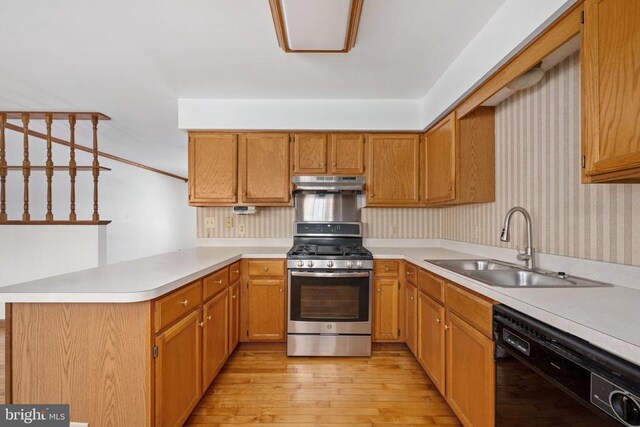 kitchen with under cabinet range hood, a sink, a peninsula, dishwasher, and stainless steel gas range