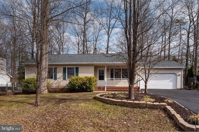 single story home with aphalt driveway, a front lawn, covered porch, and an attached garage