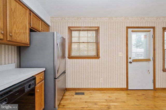 kitchen with visible vents, dishwasher, wallpapered walls, and light countertops