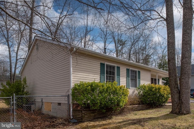 view of side of property featuring a gate, crawl space, and fence