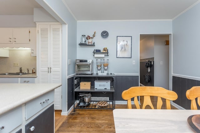 dining area featuring ornamental molding, dark hardwood / wood-style flooring, and sink