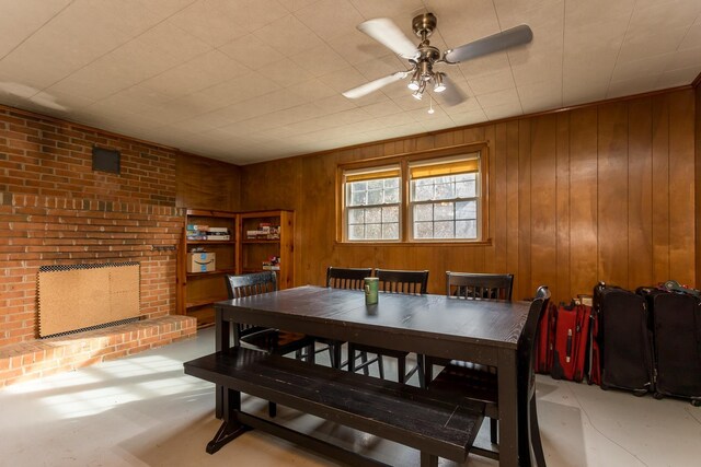 dining space featuring ceiling fan and wood walls