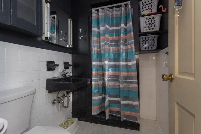 bathroom with tile walls, sink, toilet, and walk in shower