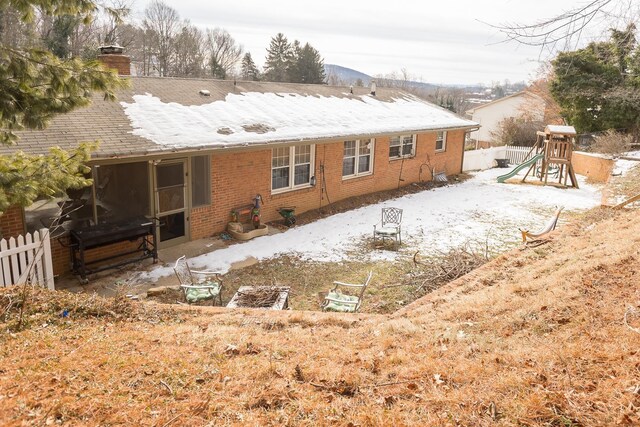 rear view of property featuring a playground