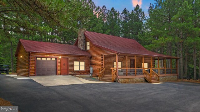 log-style house featuring a porch and a deck