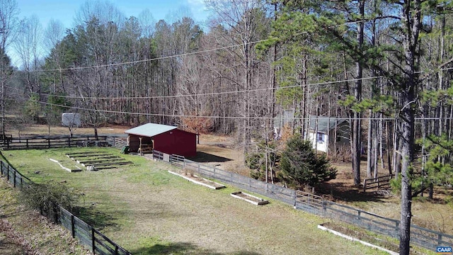 view of yard featuring an outbuilding, a garage, fence, driveway, and an exterior structure