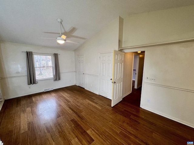 spare room featuring high vaulted ceiling, dark wood-style flooring, visible vents, and a ceiling fan