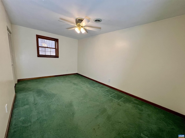 carpeted spare room featuring baseboards, visible vents, and ceiling fan