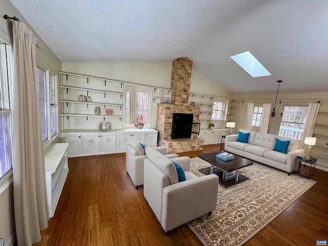 living room featuring dark wood-type flooring, a textured ceiling, and lofted ceiling with skylight