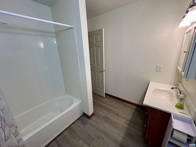 bathroom with shower / tub combo with curtain, vanity, baseboards, and wood finished floors