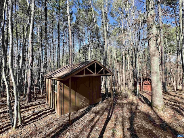 view of shed with a view of trees